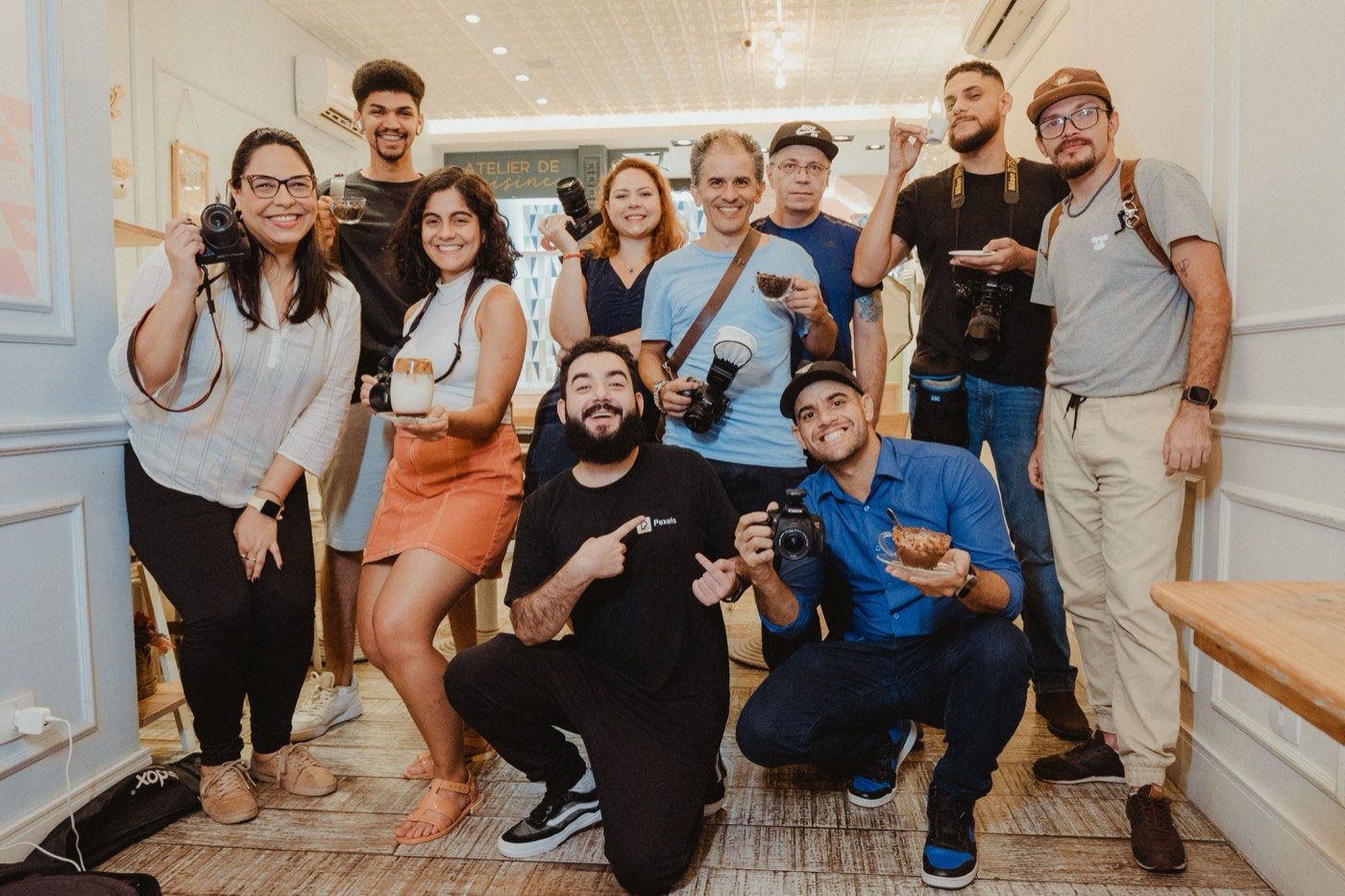 A large group of young creatives posing together in a bright studio