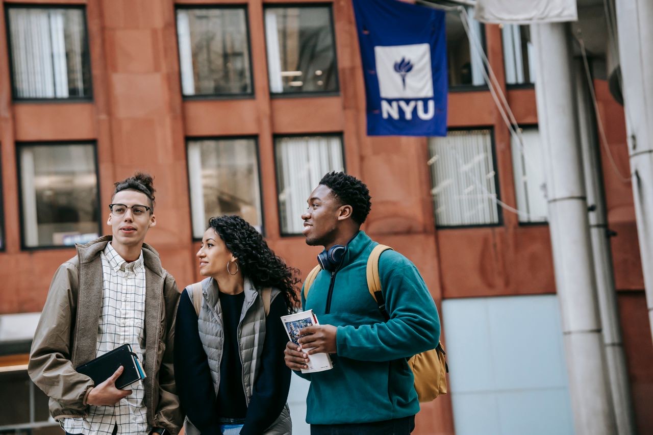 Three students talking outside a university building in Greenwich Village